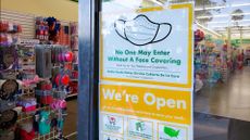 A storefront sign reads: "No one may enter without a face covering."