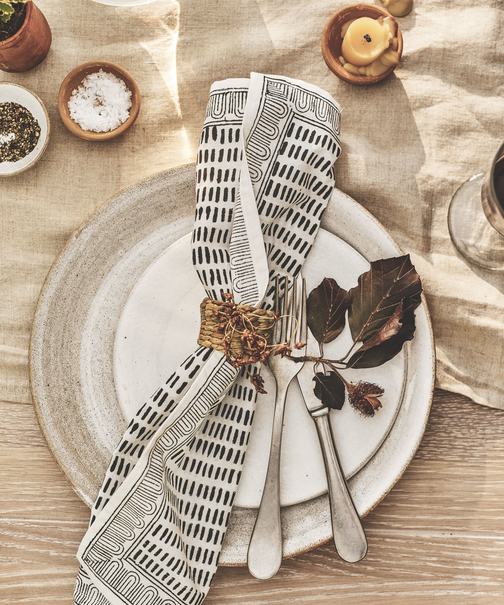Cream linen tablecloth with white plates and black and white patterned napkins