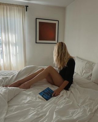 Woman lying in bed with a book