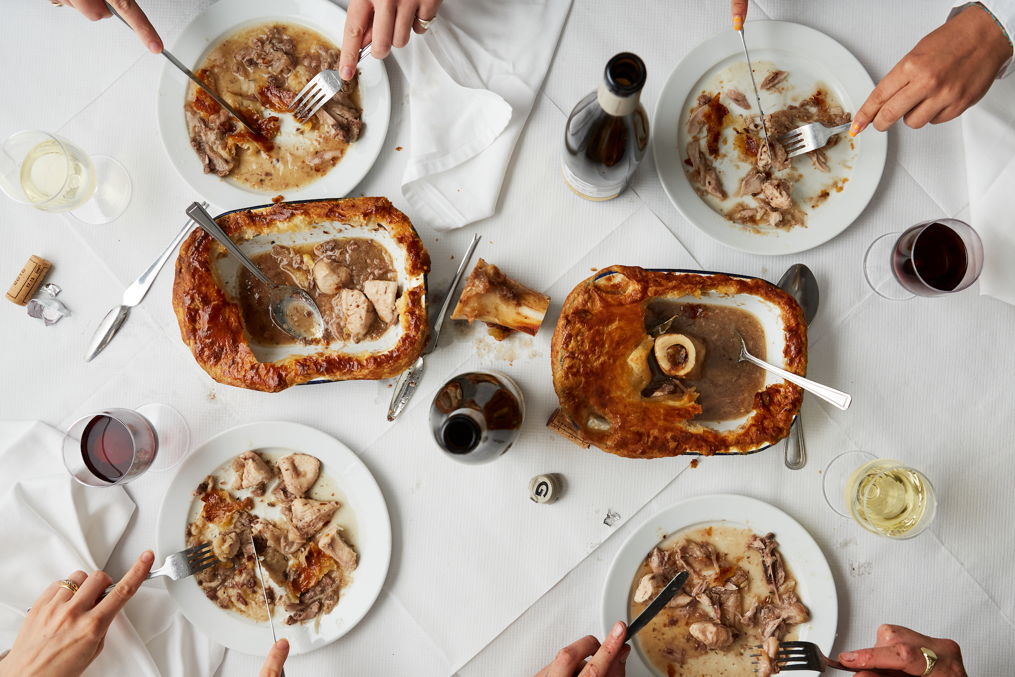 Aerial view of two game pies on a white tablecloth