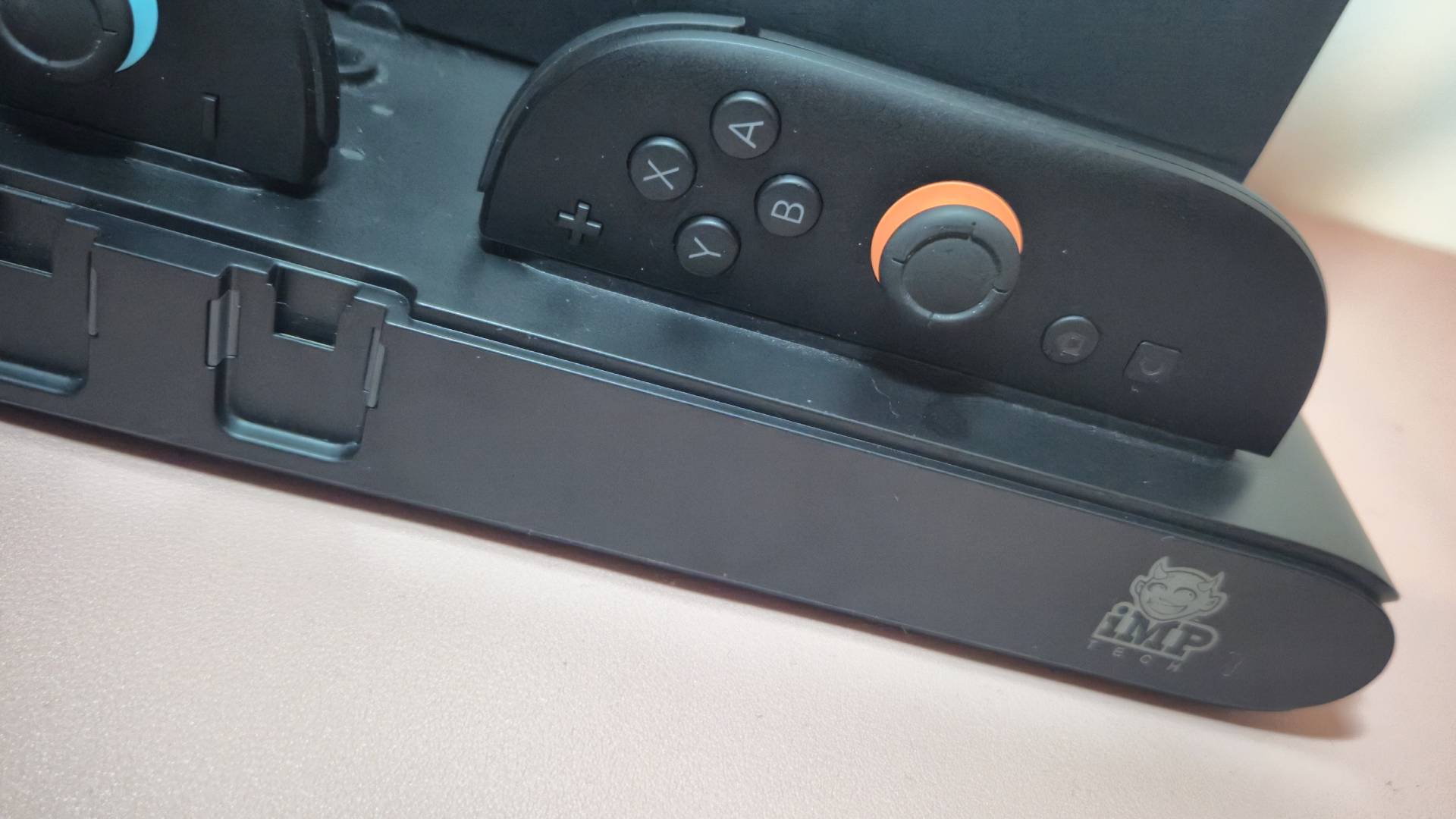 Close up photo of the right Switch 2 Joy-Con sitting in the base of a charging stand.