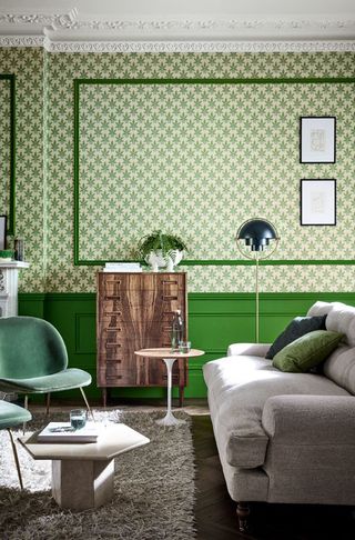 Green printed living room wallpaper with grey sofa shaggy rug and mid century chest