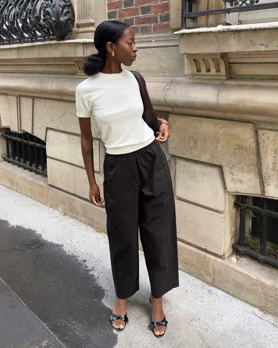 woman wearing white top, black trousers and black kitten heels