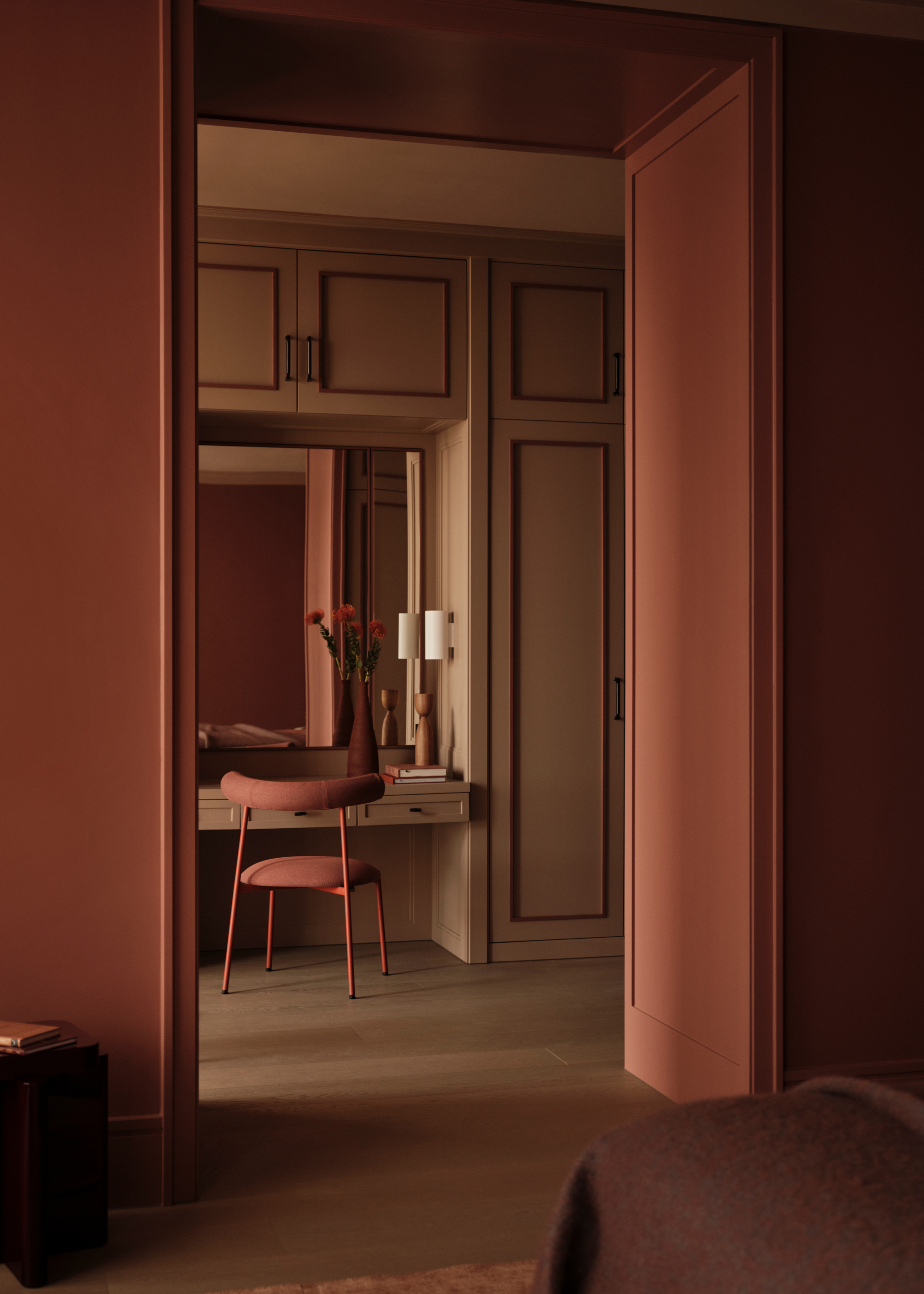 A modern dressing room adjoining the primary bedroom decorated in earth tones with built in wardrobes with trim and panel detailing