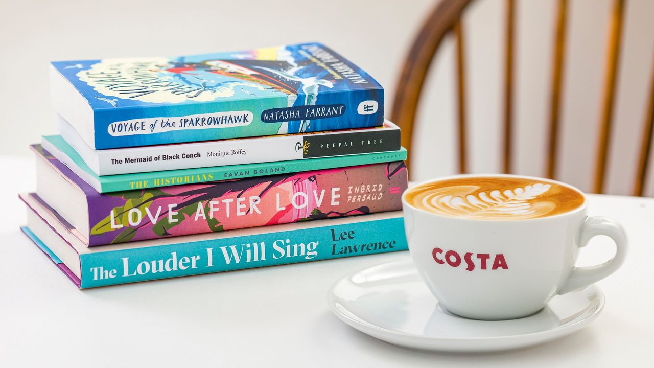 Lifestyle shot of a costa coffee cup and a stack of the Costa Book Awards 2020 category winners