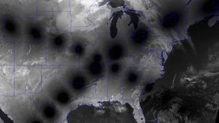 O imagine din satelit a SUA în alb-negru, cu căile de umbră ale lunii formând o cruce.