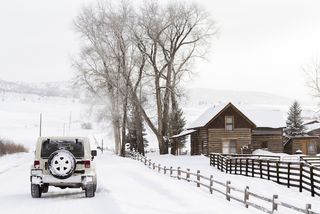 Car driving by winter house