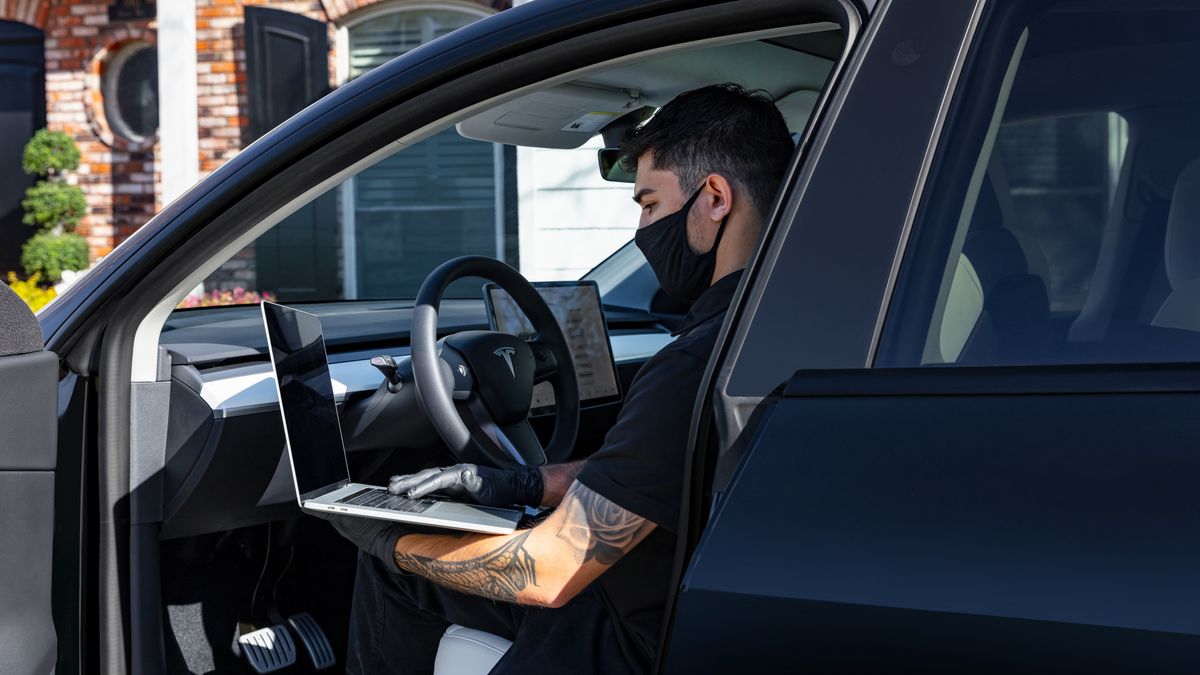 man sitting with laptop sitting in a Tesla