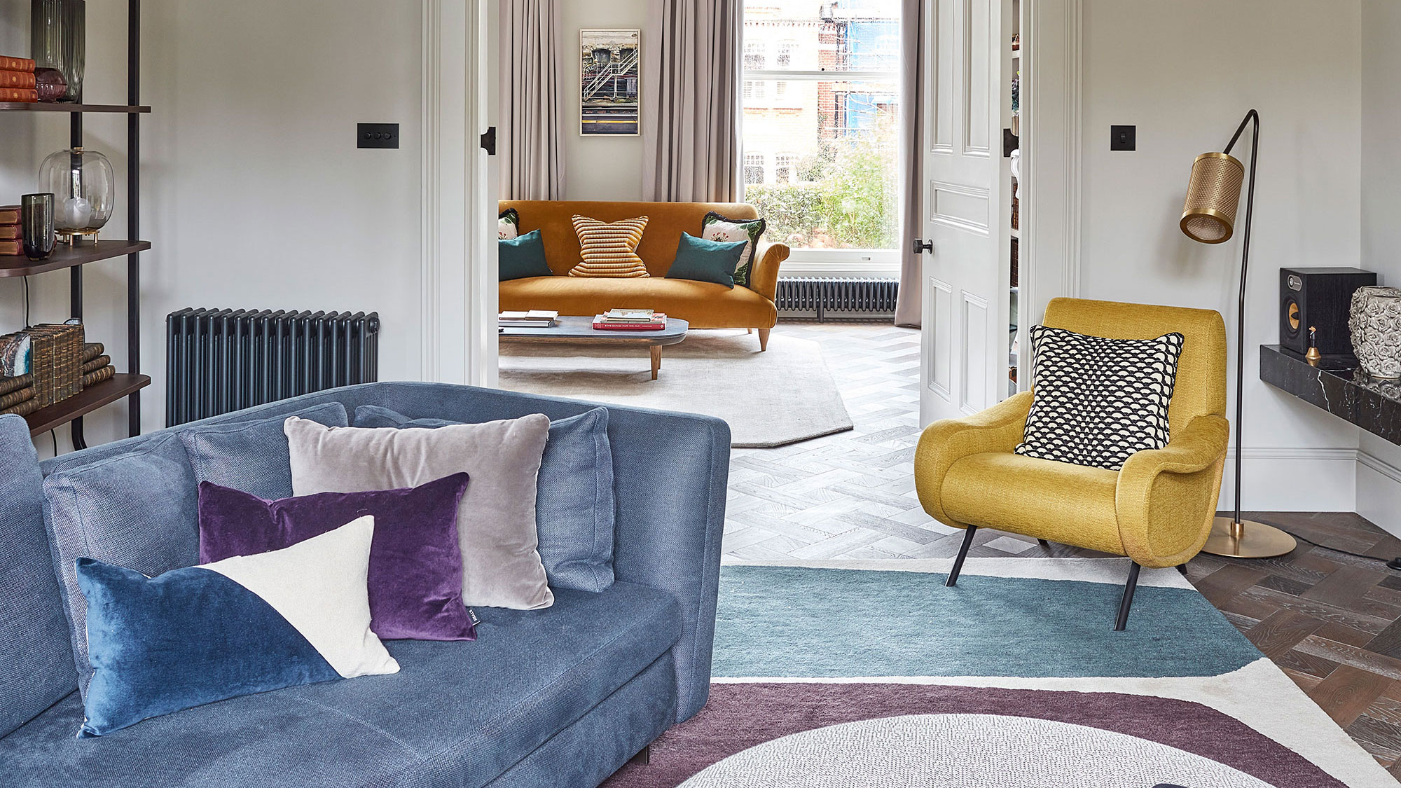 retro living room with parquet flooring and blue velvet sofa