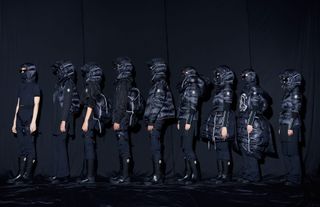 Line of models in Moncler Gentle Monster balck puffer hoodies and boots