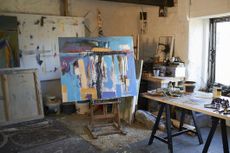 A large canvas painting on an easel in a creative artist studio