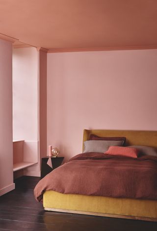 Pink bedroom with red and orange bedding
