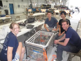 Members of the University of California, San Diego Microgravity Team wait with their biofuel fire experiment apparatus ahead of a weightless flight as part of NASA's Microgravity University Program.