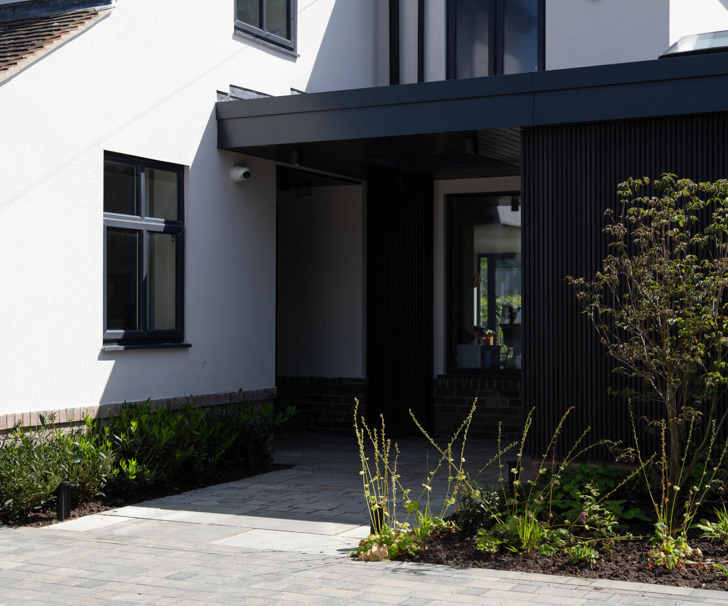 front of modern house with paved driveway and planted areas
