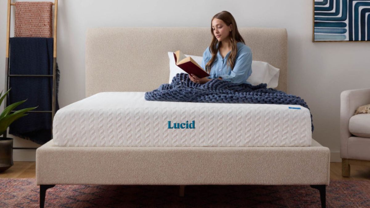 A woman reads a book on the Lucid Memory Foam Mattress