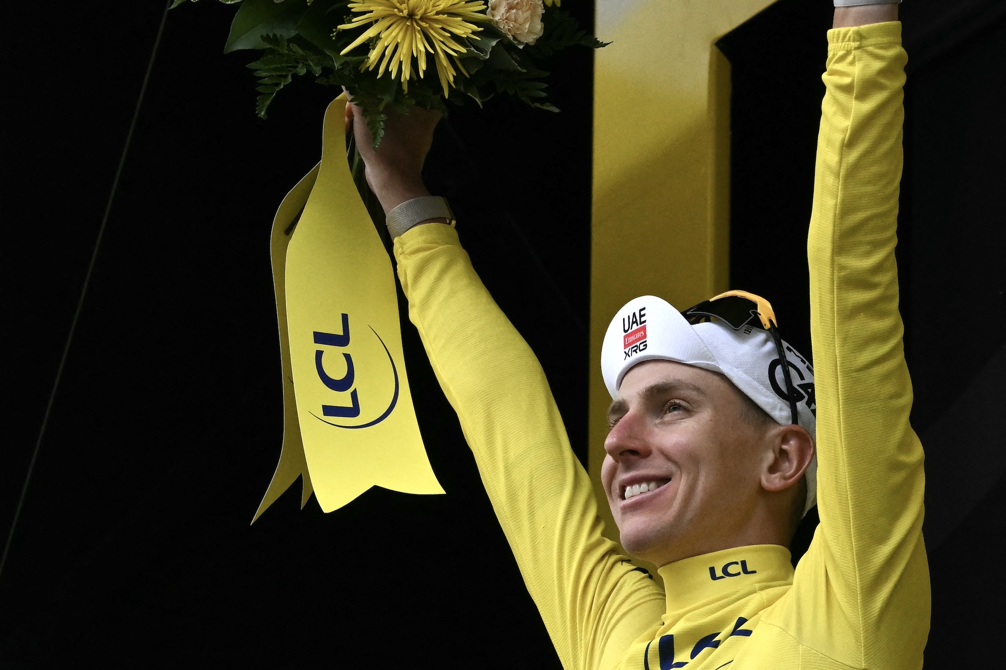 UAE Team Emirates - XRG's Tadej Poga&amp;#269;ar celebrates on the podium with the overall leader's yellow jersey after the 6th stage