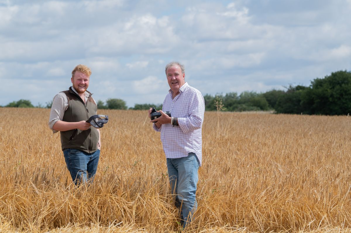 Jeremy Clarkson and Kaleb Cooper smiling in a field holding goggles