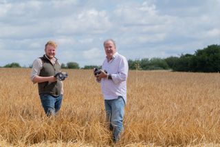 Jeremy Clarkson and Kaleb Cooper smiling in a field holding goggles