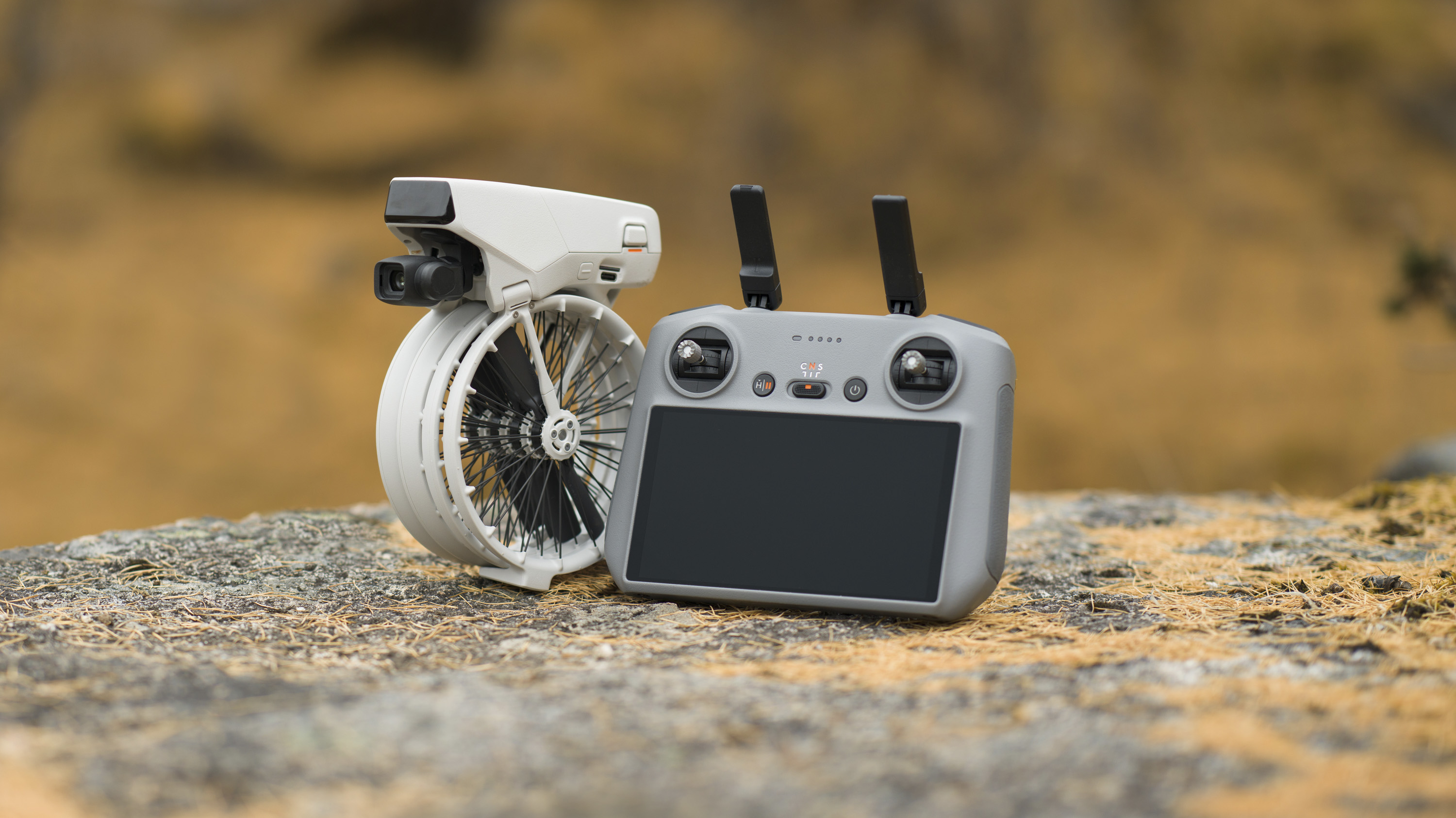 DJI Flip drone on a rock alongside the RC2 controller