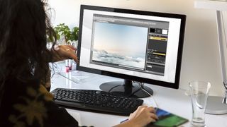 En kvinna sitter vid sitt skrivbord och använder Photo Pos Pro