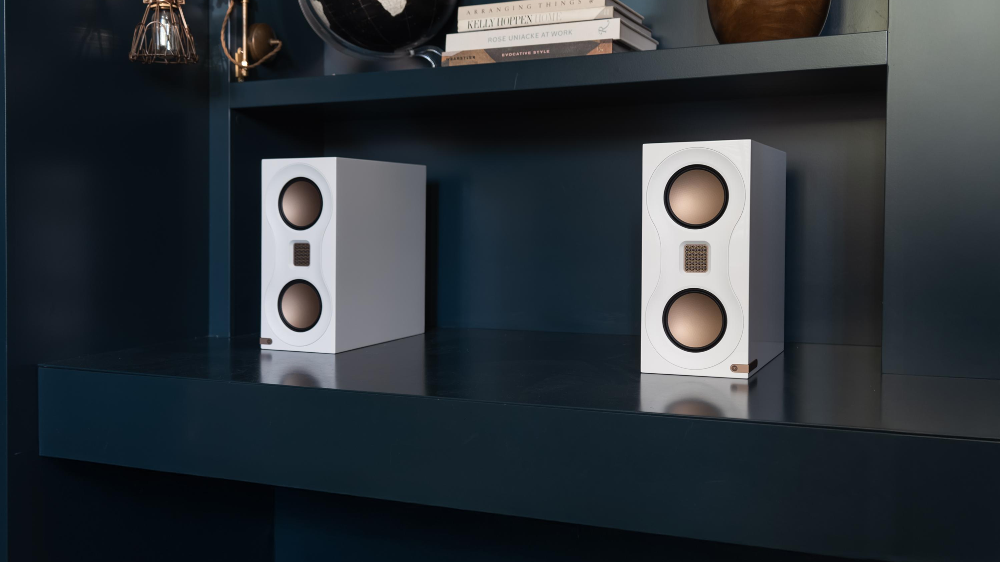 Monitor Audio Studio 89 speakers in high gloss white in a black bookshelf
