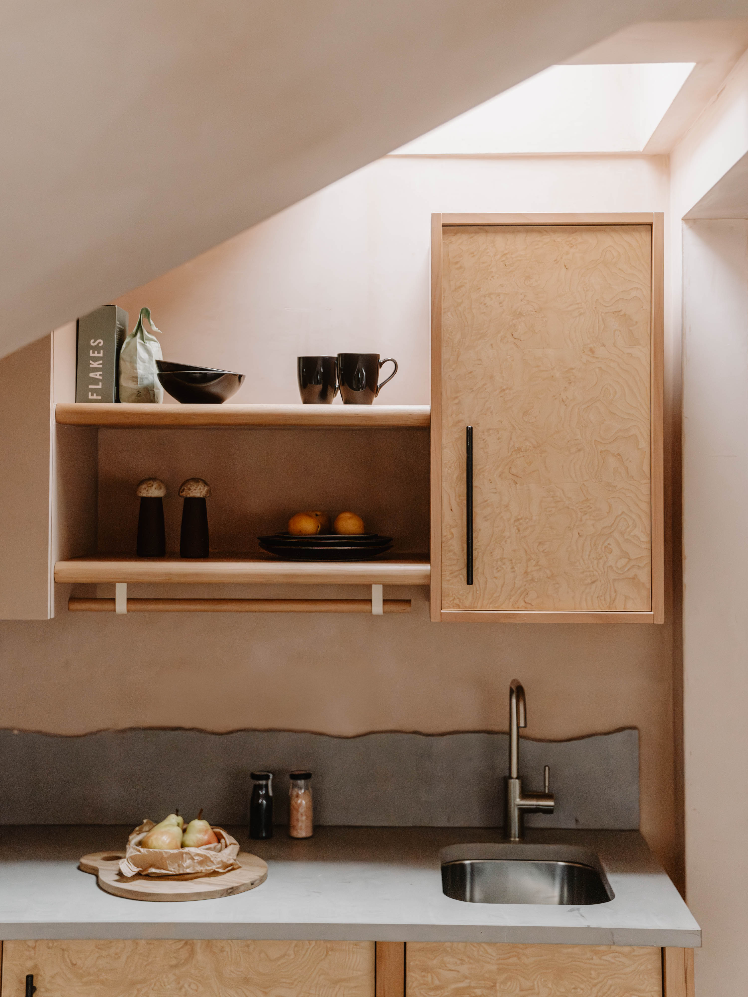 A neutrally tinted hotel with argilla-toned walls, sculptural furnishings, wooden surfaces, and curated art and tilework.