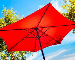 bright red patio umbrella against a blue sky