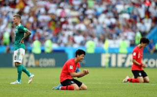 South Korea's Son Heung-min sinks to his knees after victory over Germany at the 2018 World Cup as Toni Kroos looks dejected.