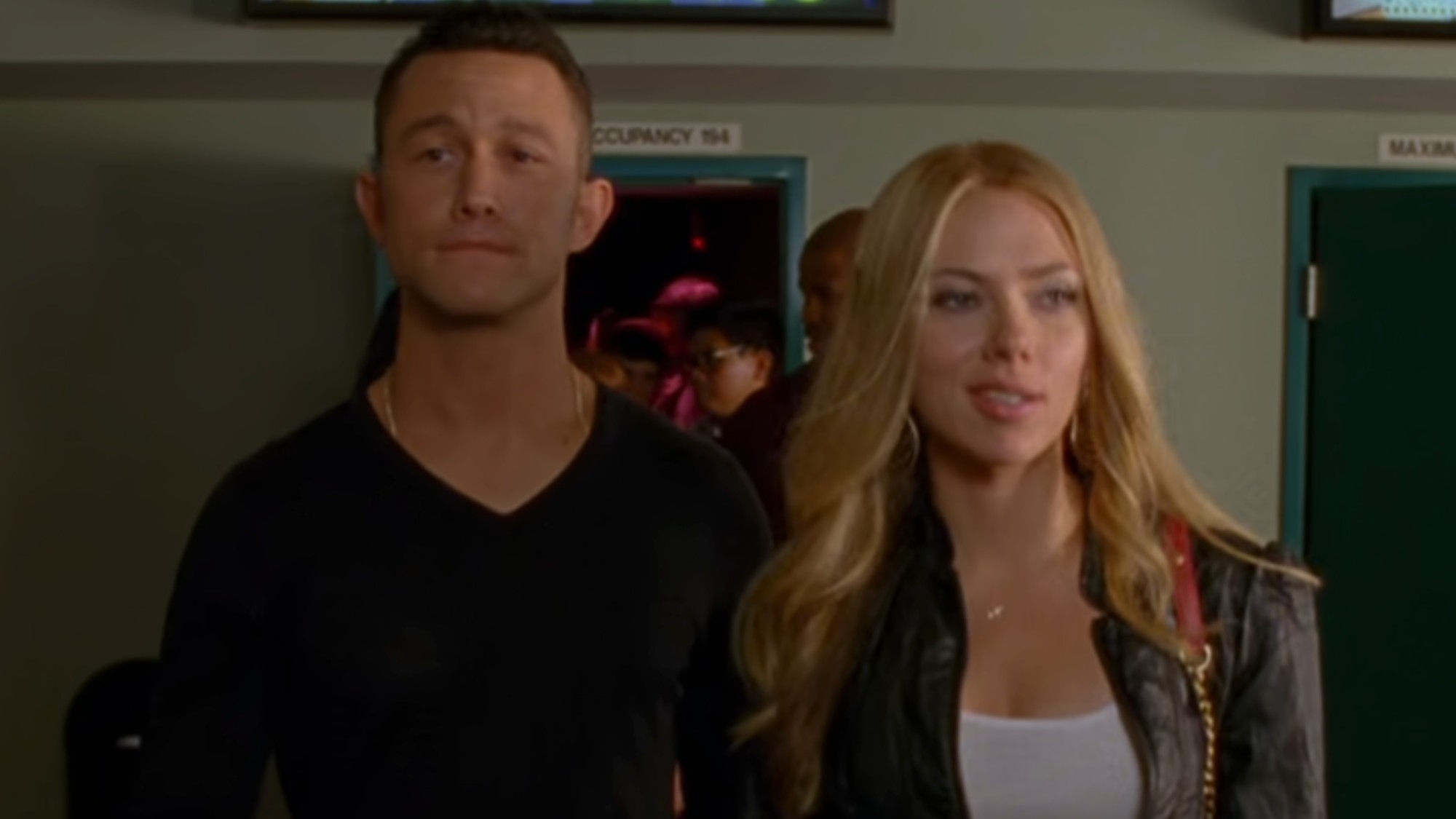Joseph Gordon-Levitt in a black sweater, walking out of a movie theater with Scarlett Johansson in Don Jon