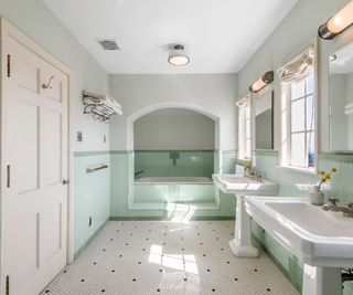 Green bathroom, white tiled floor, twin sinks