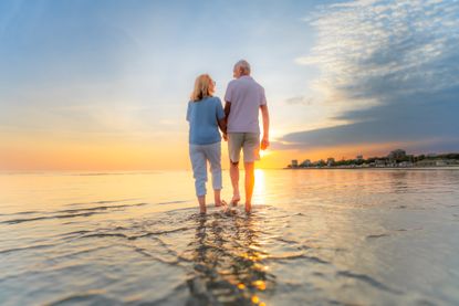 Couple walking on the beach at sunset