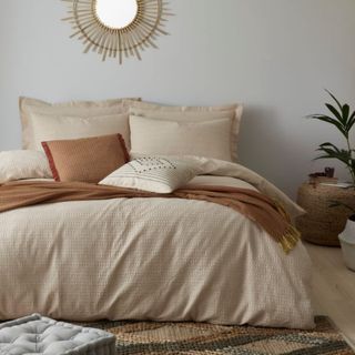 Neutral coloured bedding in neutral bedroom