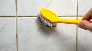 cleaning grout with scrubbing brush
