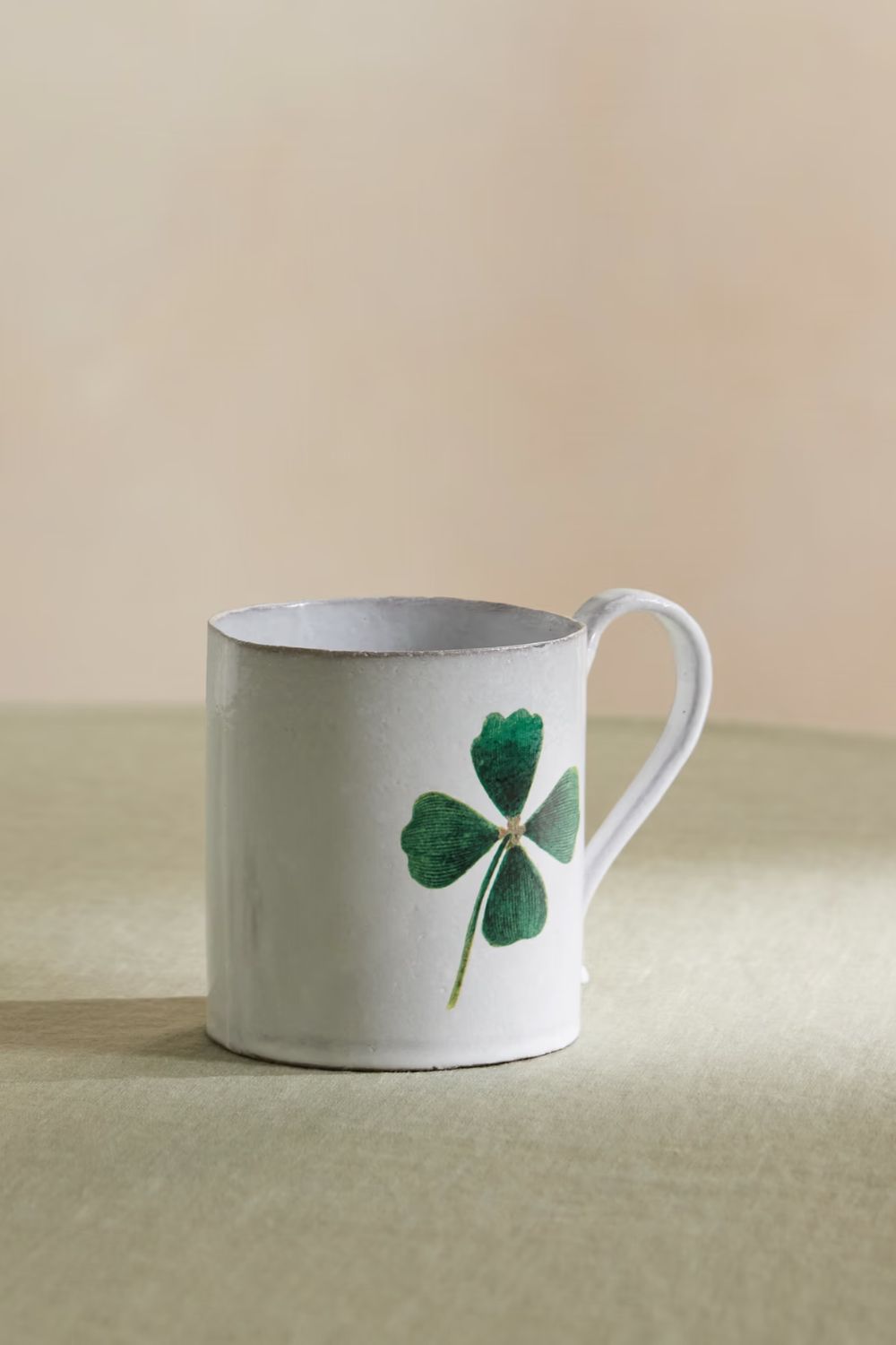 White mug with green four leaf clover motif
