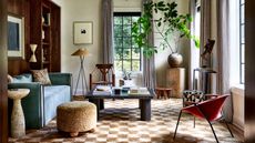 a modern living room with a accent chairs and stools and a checkerboard rug