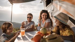 Family eating outside their camper van