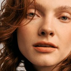 A model with red hair wearing Lancôme L'Absolu Rouge Lipstick