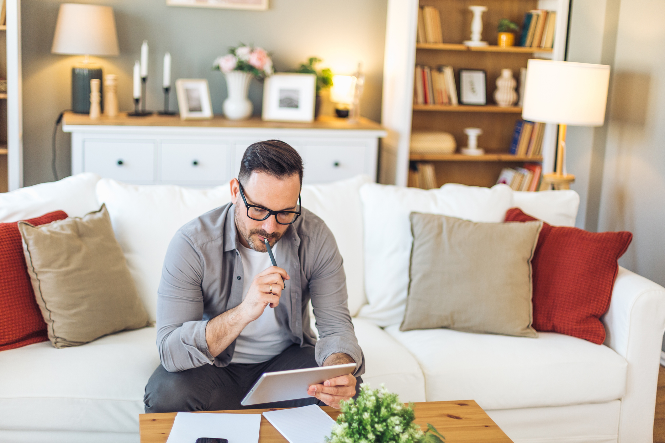 Man sitting on sofa wondering what to do with investment trusts that are targeted by Saba