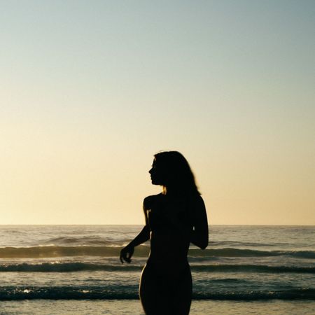 A woman running into the sunset on the beach