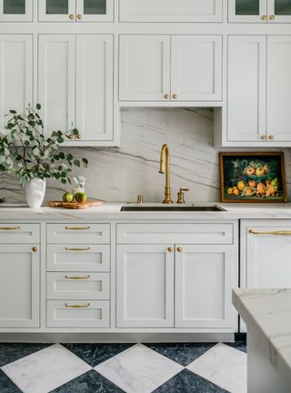 White kitchen with marble backsplash and gold hardware