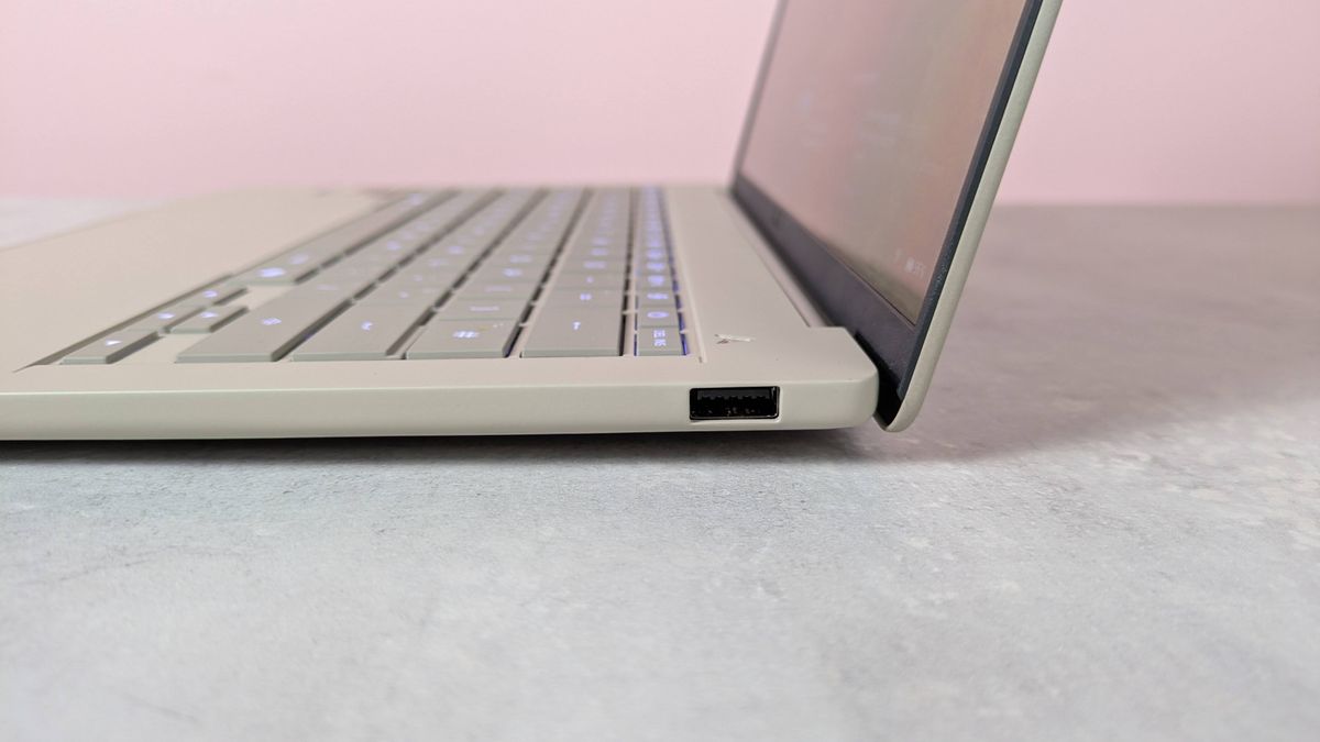 Close-up of USB-A port on right-hand side of Asus Zenbook A14, on a desk with pink wall in background