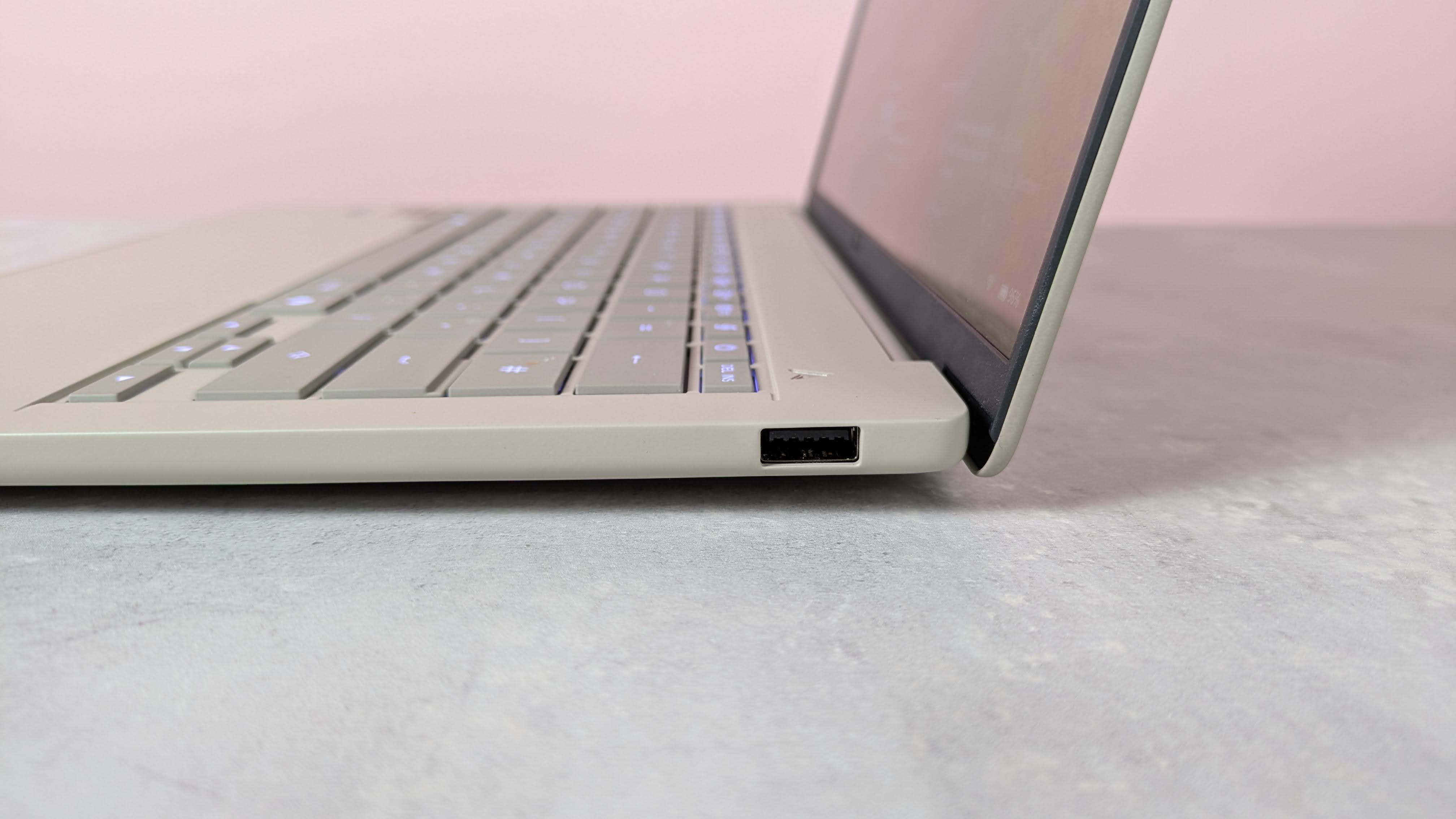 Close-up of USB-A port on right-hand side of Asus Zenbook A14, on a desk with pink wall in background