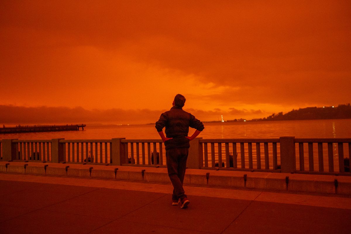 A man watches California wildfire smoke blot the sky in September 2020.