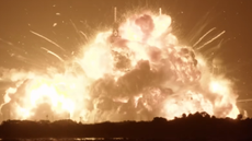 A fireball erupts from a launchpad.