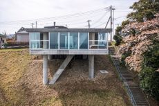 concrete japanese house called torus house perched on a hill, example of contemporary japanese architecture