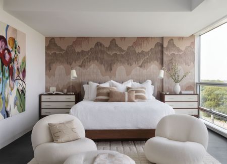 minimalist bedroom in white with feature wall and city skyline views