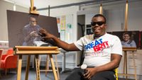 Student shows off painting they created. 