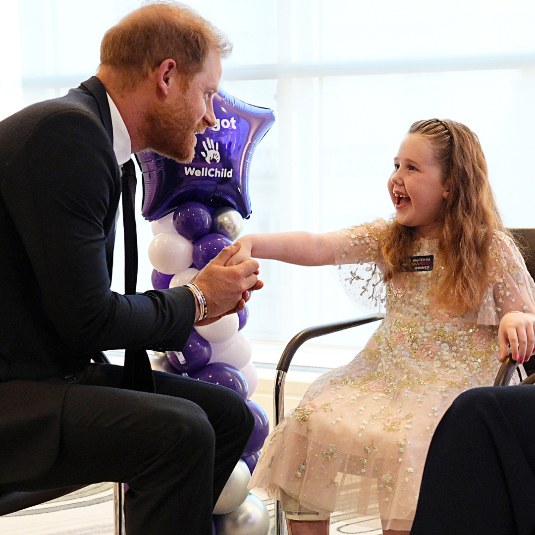 Prince Harry shaking hands with a little girl at the WellChild Awards