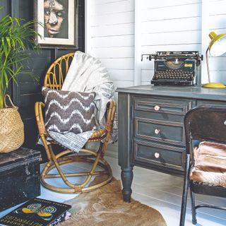 A home office with a rattan chair in the corner for relaxing