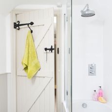 White wooden bathroom door with hanging towel